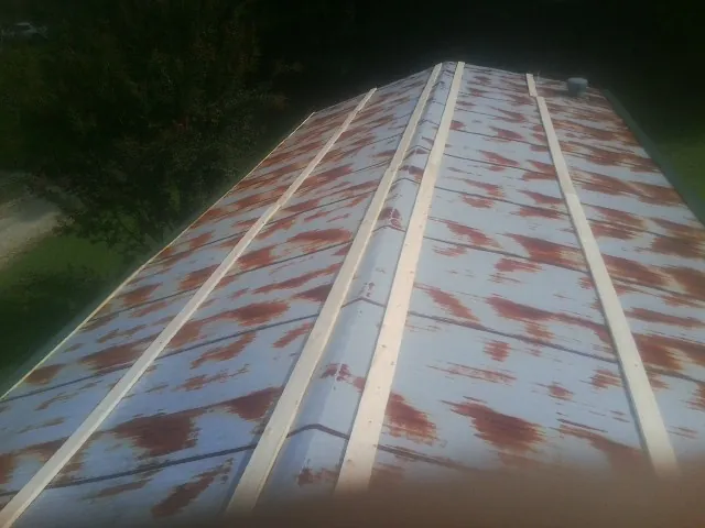 Rusted metal roof panels with new wood purlins before replacement — Storm Damage Roof Repair in Bells by Roofing Brothers