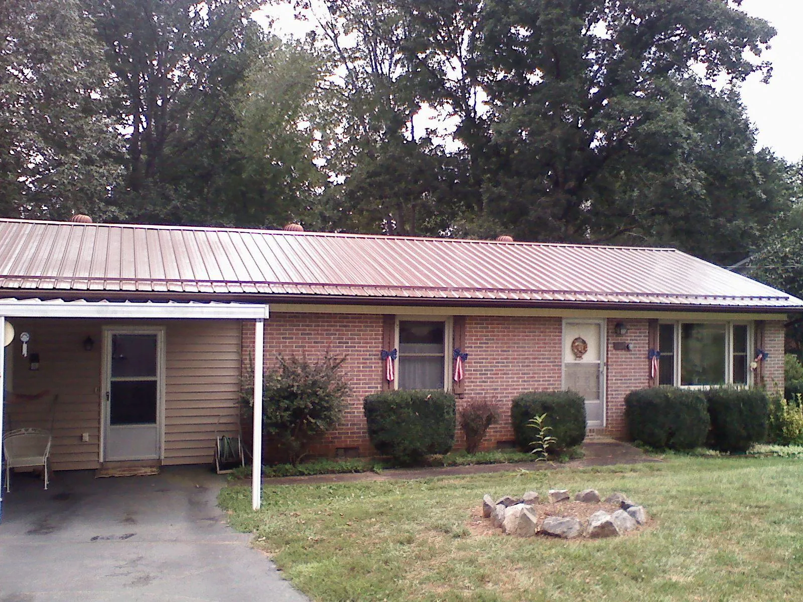 Bronze metal roof and carport on a brick ranch home — Roof Repair work by our crew in Bells
